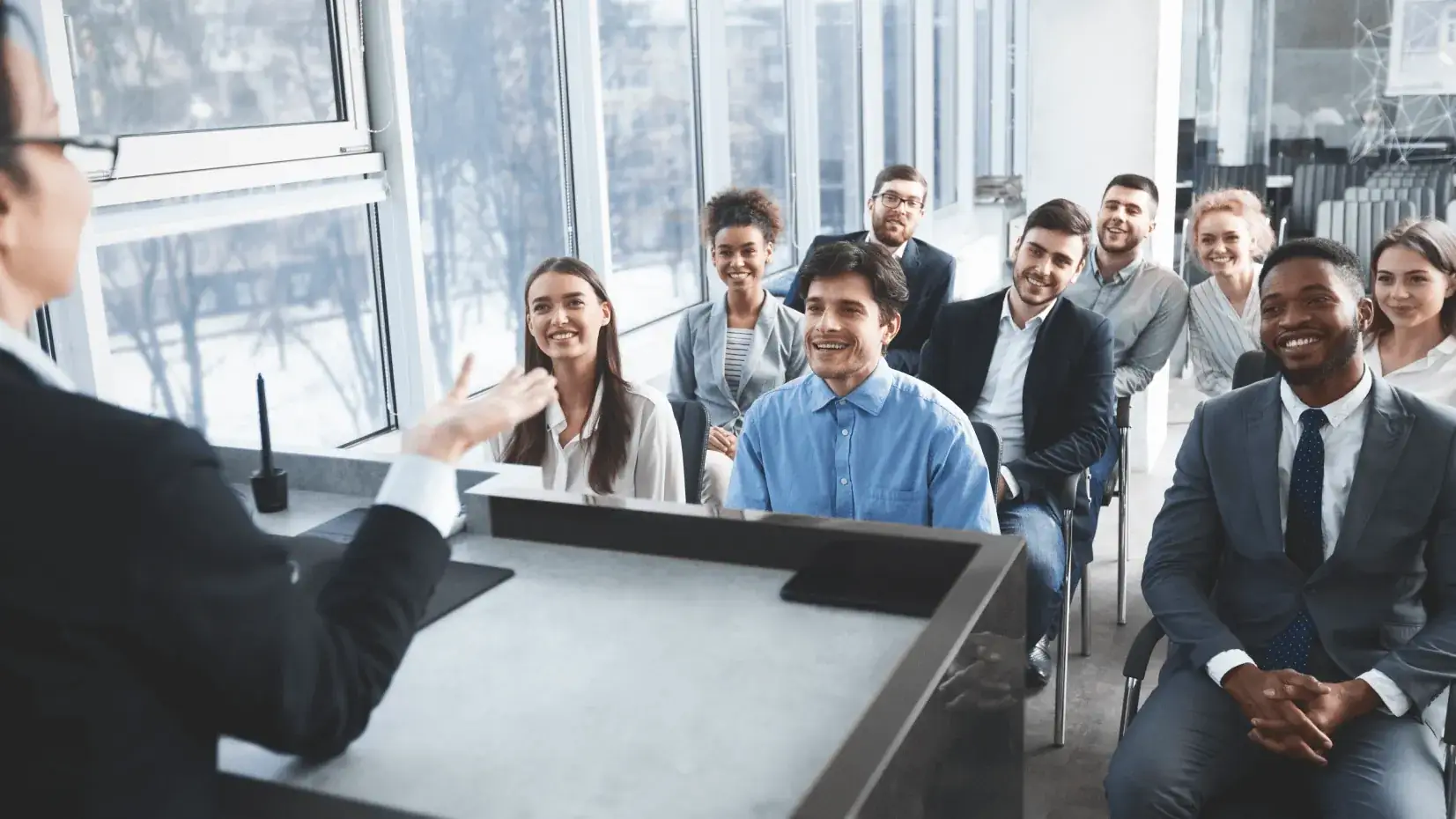 Smiling team members listening to a presenter during a training session